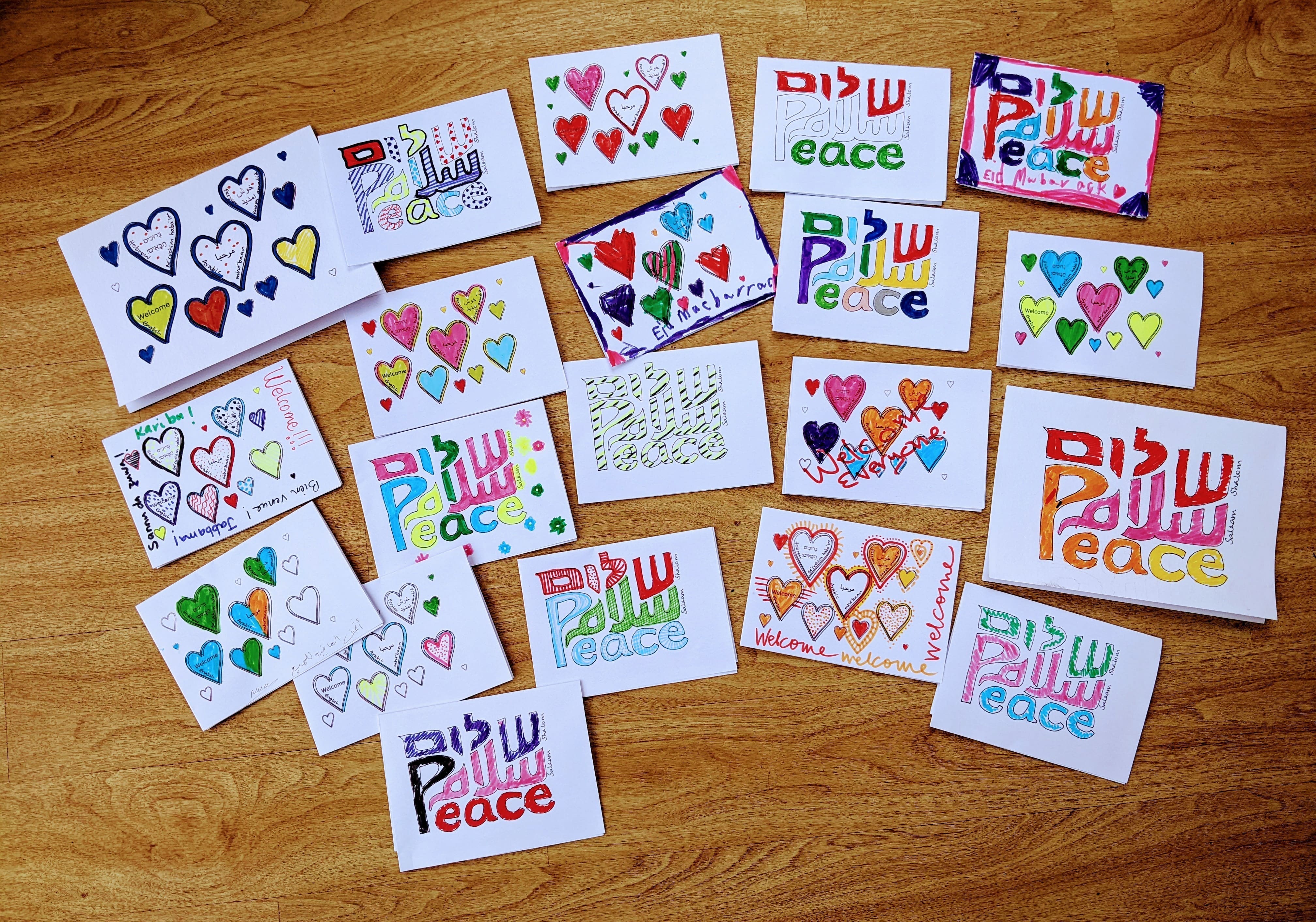 Image of many hand decorated colourful postcards created by members of the service the word peace and shalom in English and Hebrew